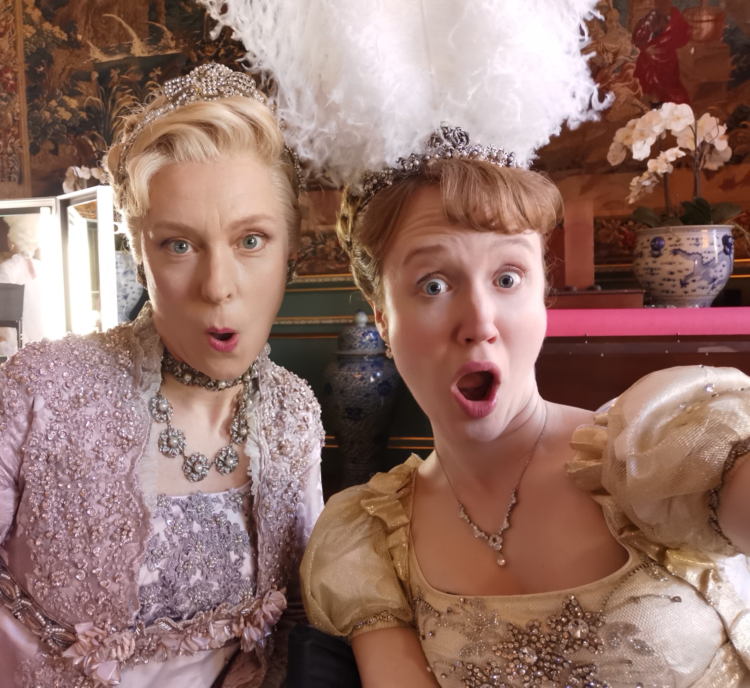 Sophie Woolley and Kitty Devlin pull comedy faces and are wearing Regency Costumes for Bridgerton season 3