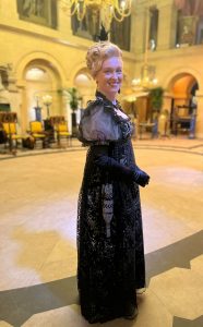 Sophie in a black regency dress on set on Bridgerton season 3